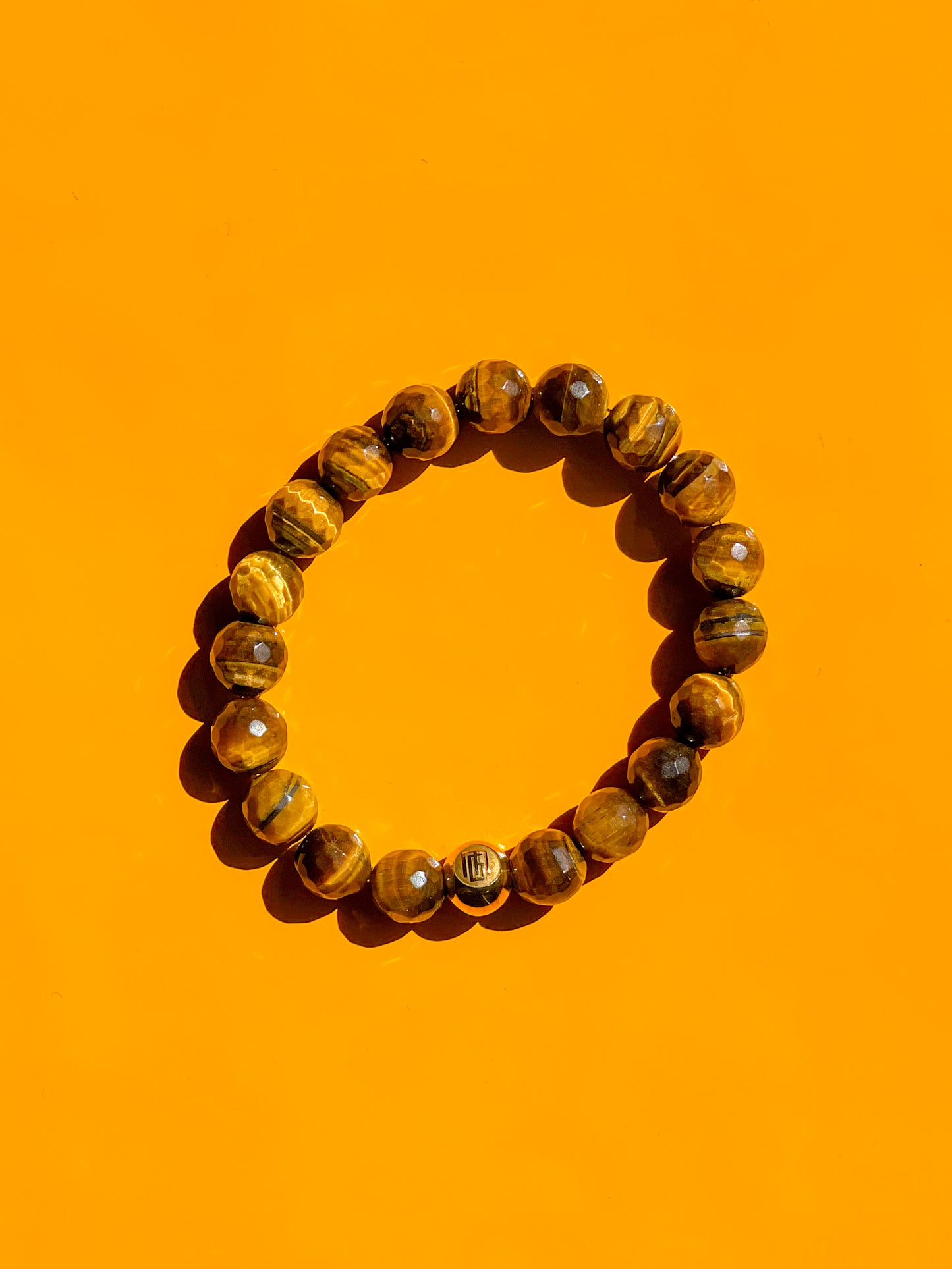 Men’s Bracelet with Tiger Eye Faceted and Gold plated over Stainless Steel logo bead.