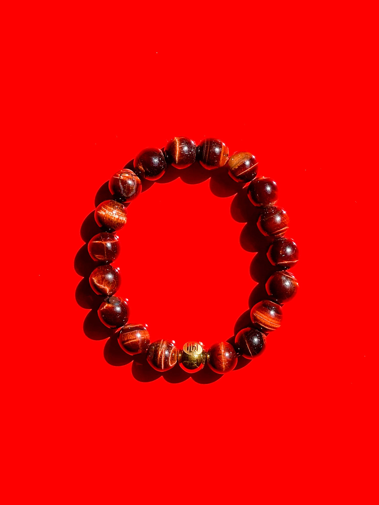 Men’s Bracelet with Red Tiger Eye and Gold plated over stainless steel logo beads.