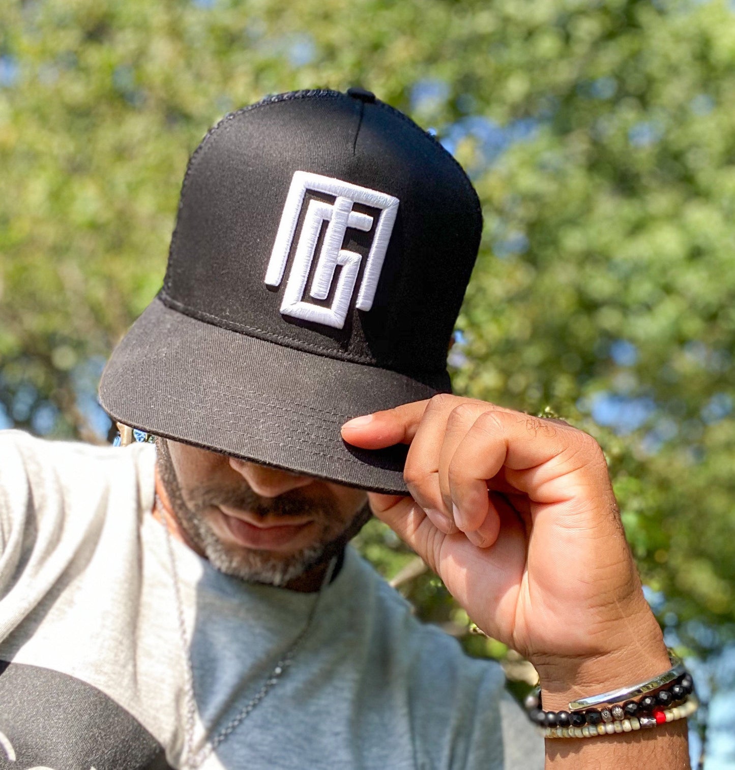 Black trucker hat with "Gregorio Mota" logo. Grgoriom Hats